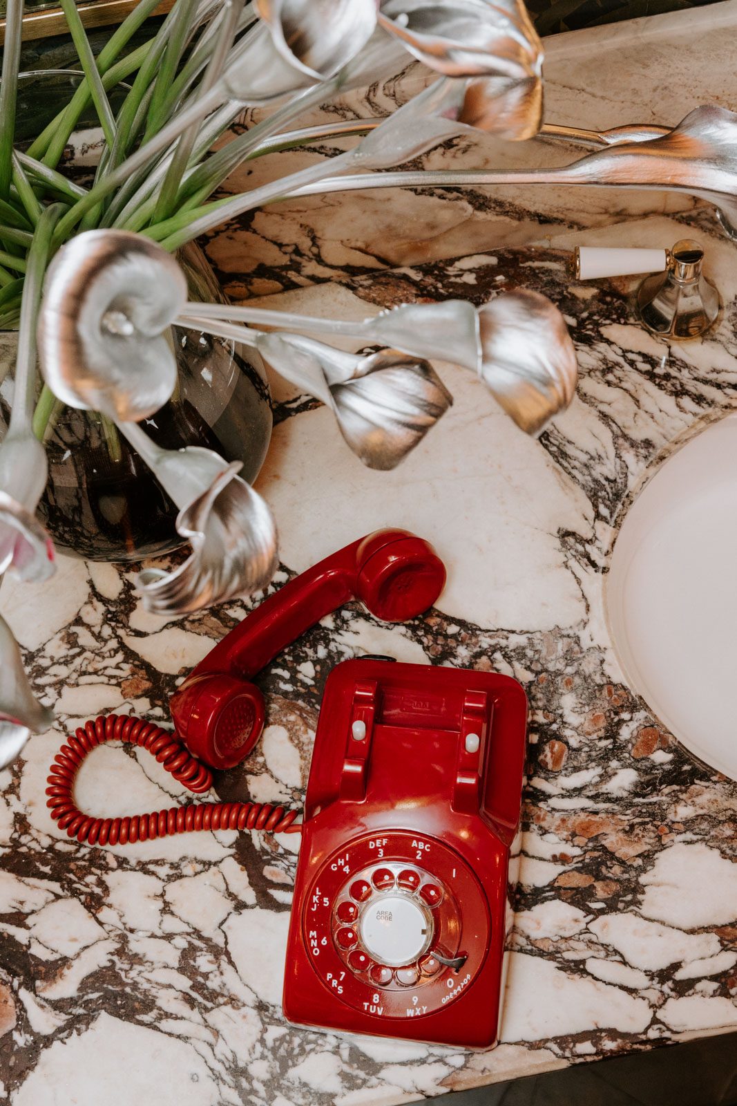 detail of Maplethorpe inspired silver lilies and vintage phone on which guests could leave voice messages for the grooms at this gay wedding at Hotel Particulier Montmartre, Paris