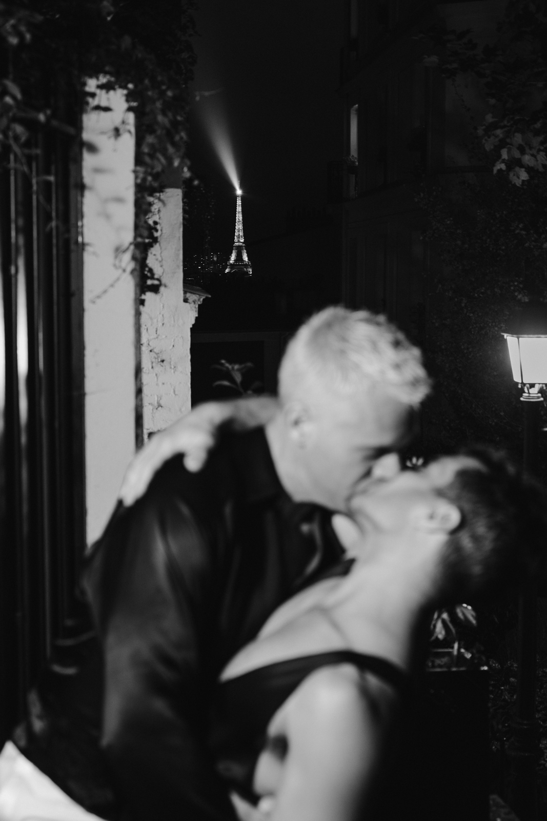 the grooms kiss at midnight in front of a lit up Eiffel tower gay at this wedding in the garden of Hotel Particulier Montmartre, Paris