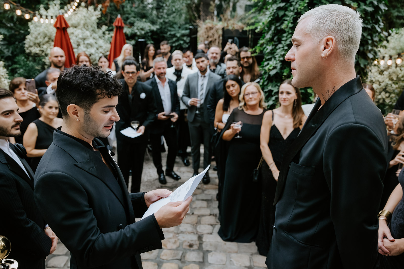 grooms exhange vows in front of guests and family at this gay wedding in the garden of Hotel Particulier Montmartre, Paris