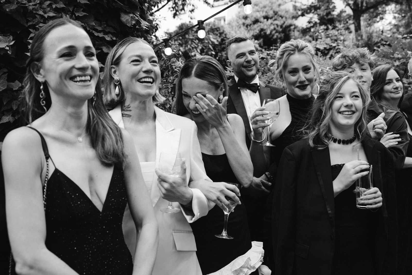 guests and family laugh during the ceremony at this gay wedding in the garden of Hotel Particulier Montmartre, Paris