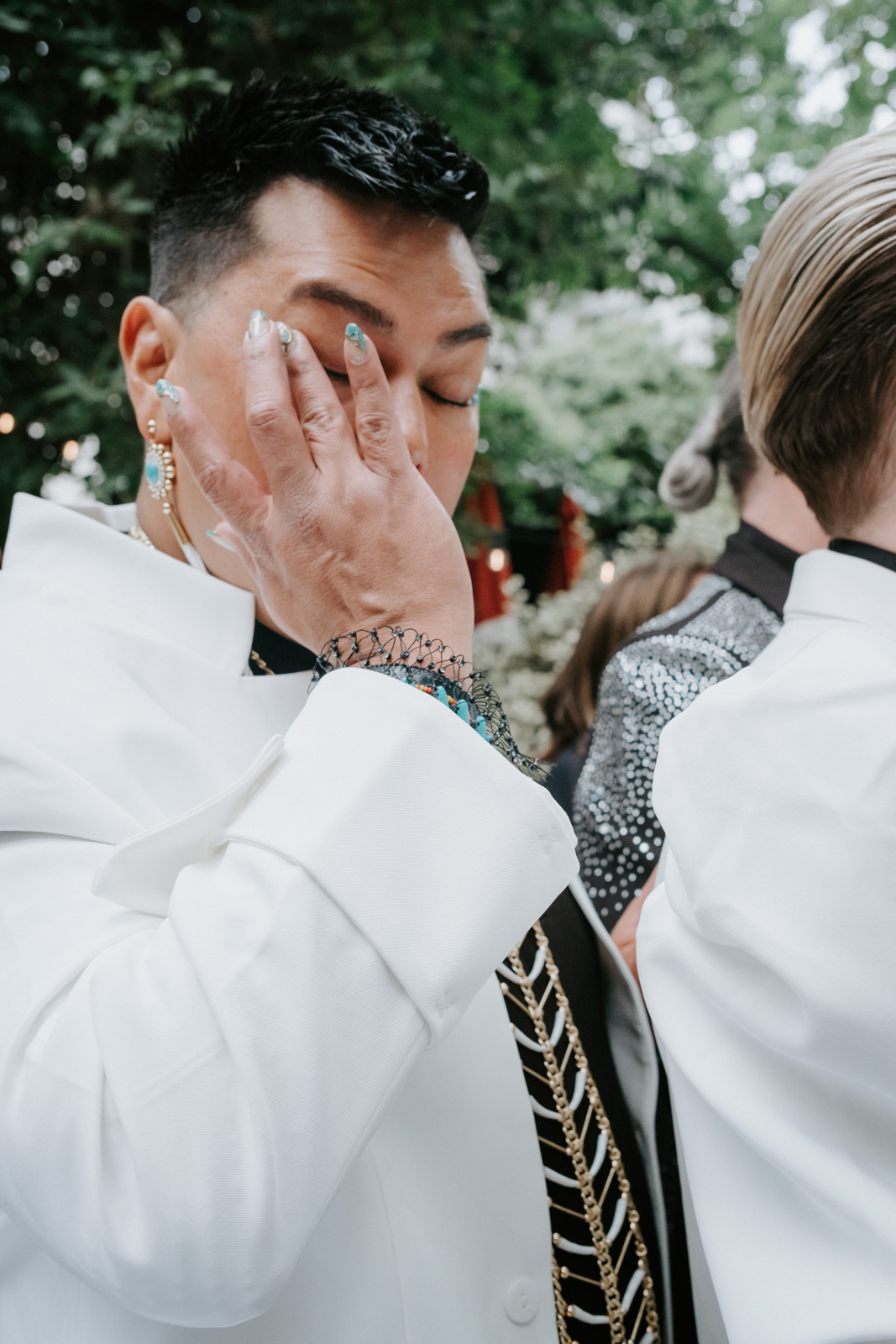 one of the guests wipes off a tear at this gay wedding in the garden of Hotel Particulier Montmartre, Paris