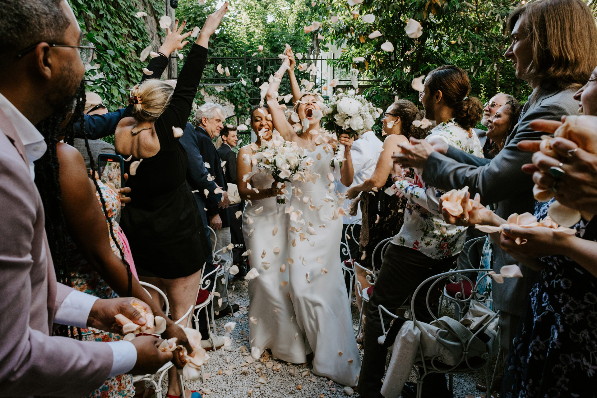 brides hooze with happiness as they exit their garden ceremony in Montmartre, Paris