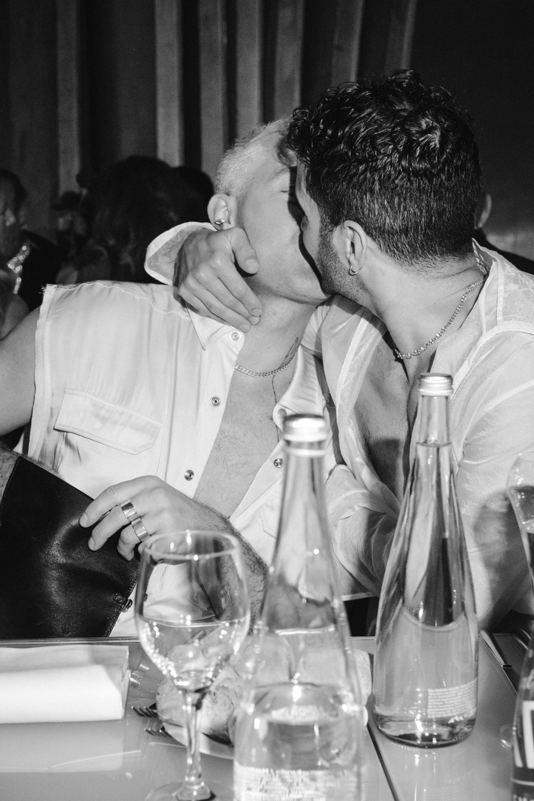 the two grooms kiss at their welcome dinner at Le Georges, on the rooftop of Pompidou Centre in Paris